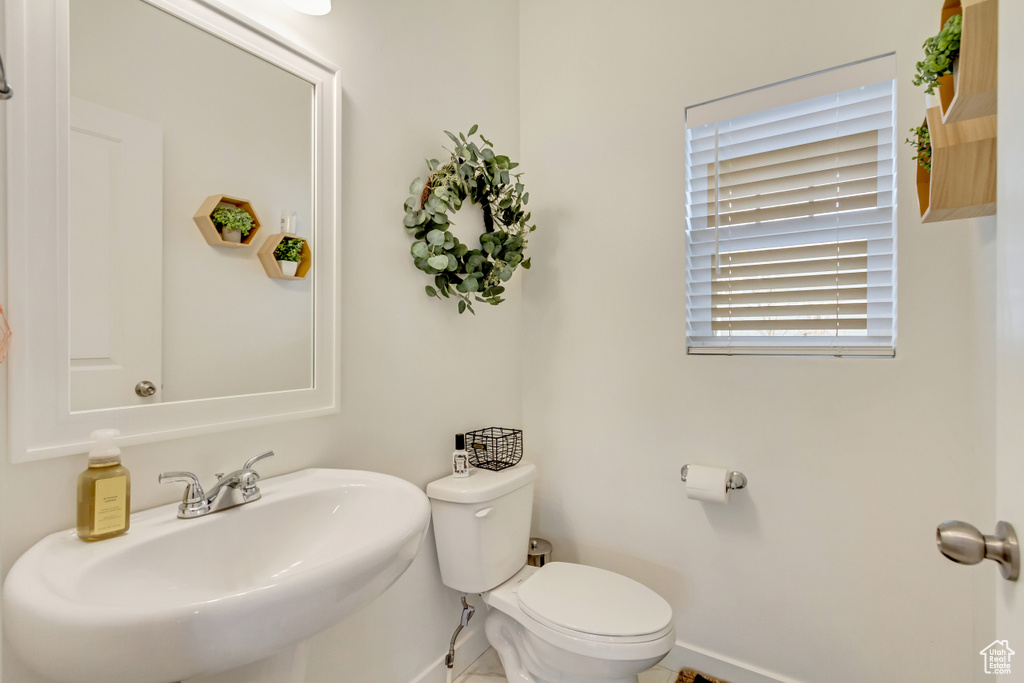 Bathroom with a sink, toilet, and baseboards