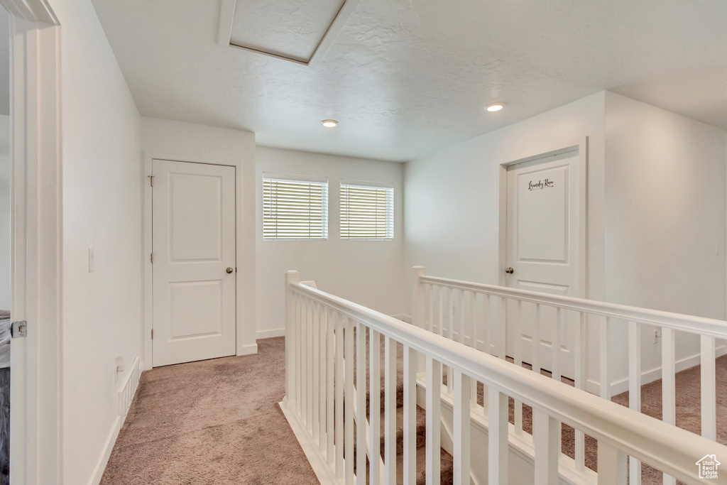Corridor with light carpet, recessed lighting, an upstairs landing, and baseboards