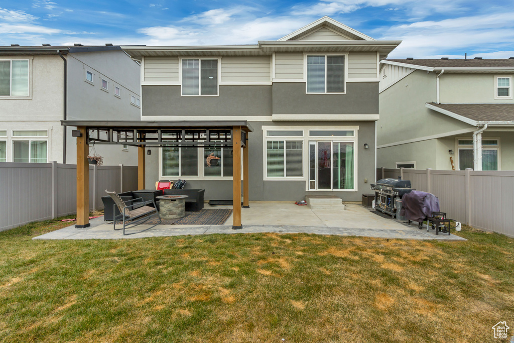 Rear view of property with a patio area, a fenced backyard, stucco siding, and a yard