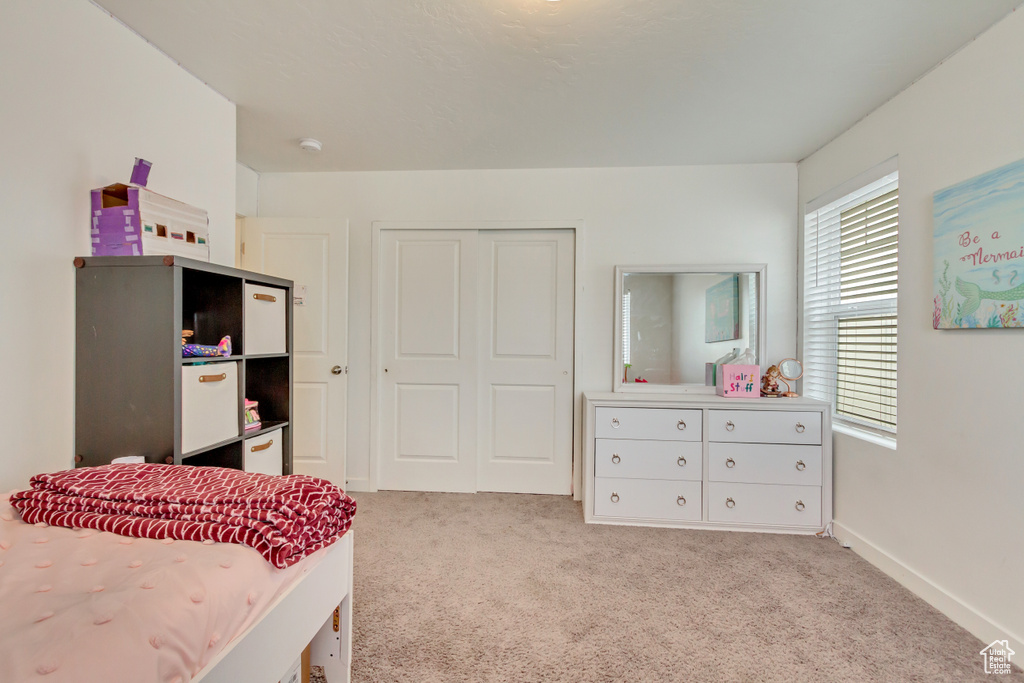 Carpeted bedroom featuring a closet and baseboards