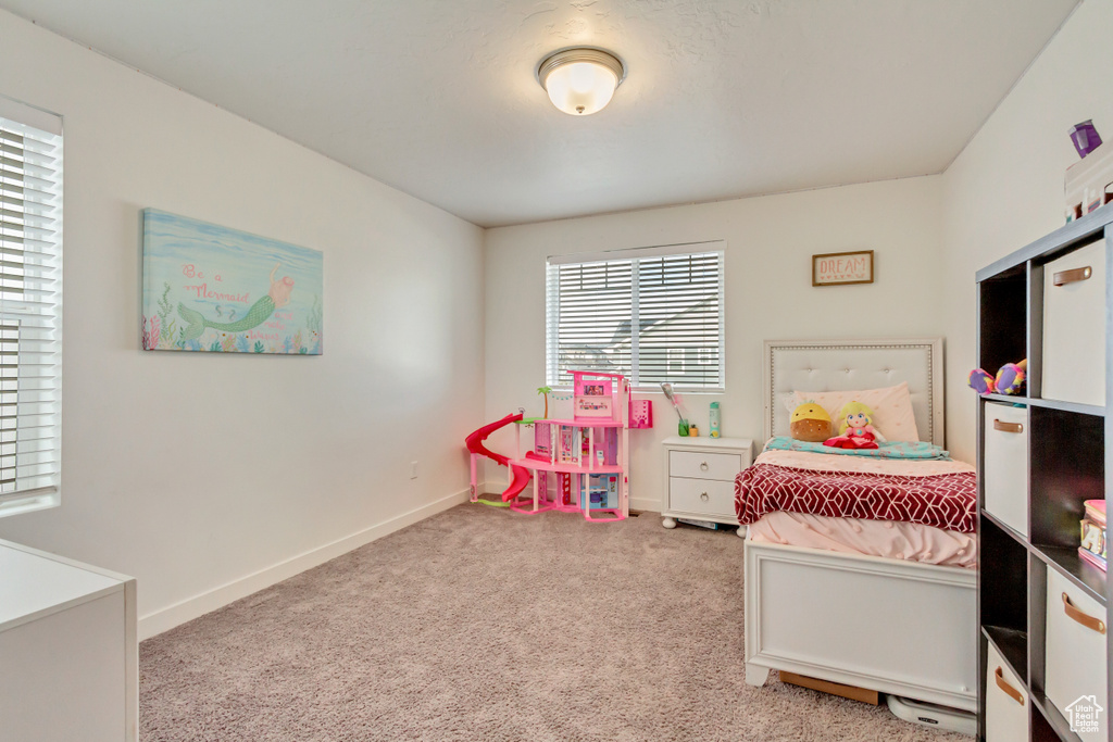 Bedroom featuring light colored carpet and baseboards