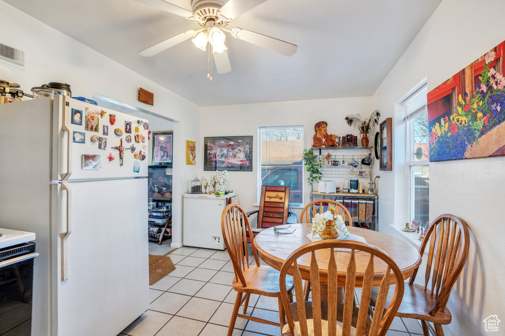 Dining space with light tile patterned floors, ceiling fan, and visible vents