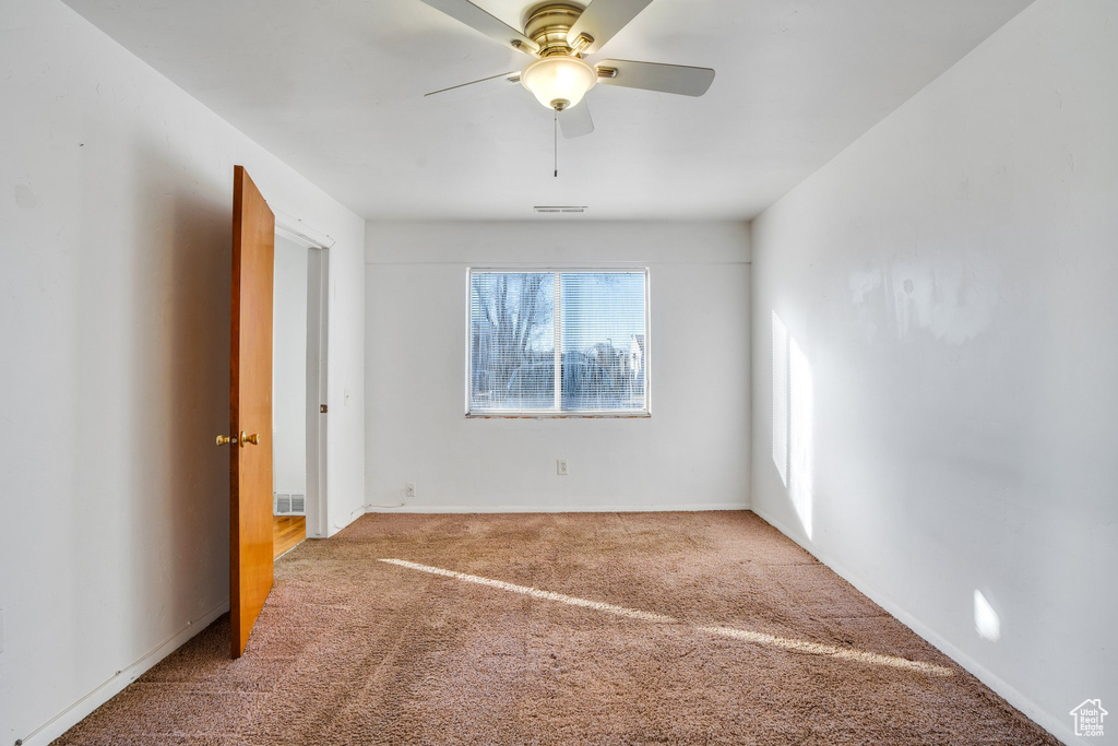 Unfurnished bedroom with ceiling fan, carpet floors, and visible vents