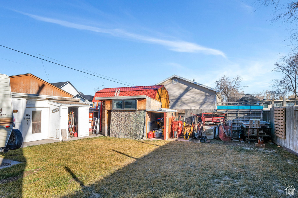 View of yard featuring a storage unit, fence, and an outbuilding