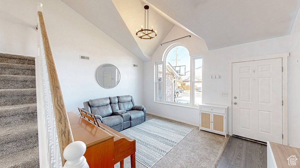 Interior space with baseboards, visible vents, lofted ceiling, stairs, and a notable chandelier