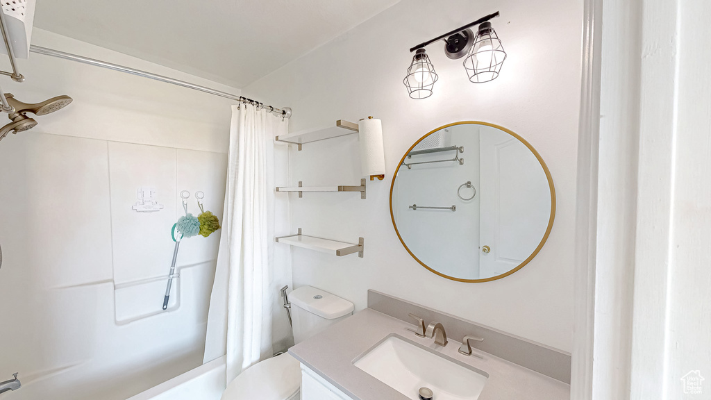 Full bathroom with a shower with shower curtain, vanity, and toilet