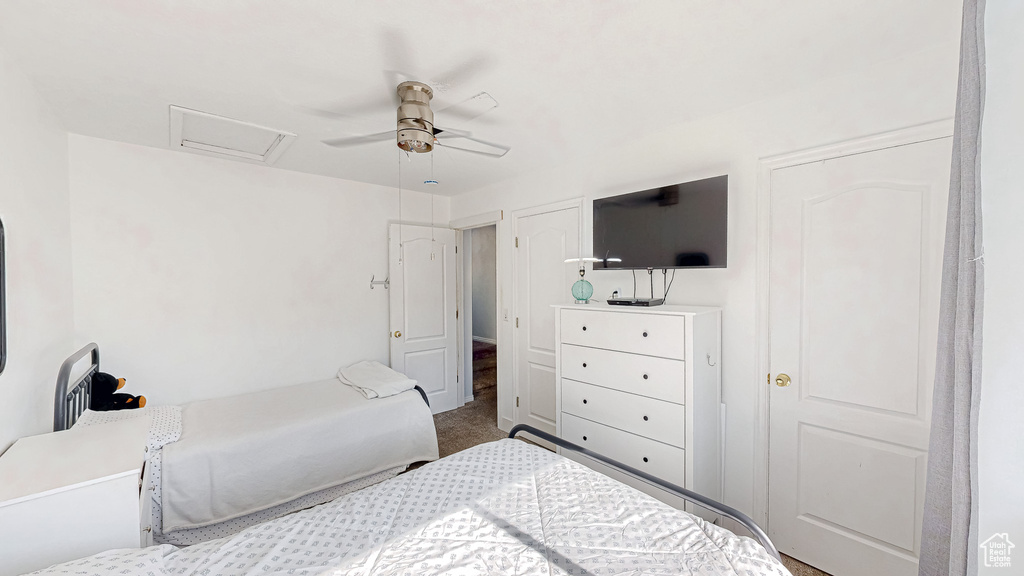 Bedroom featuring carpet, attic access, and ceiling fan