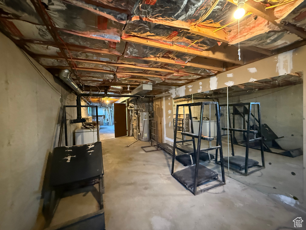 Unfinished below grade area with washer / clothes dryer and water heater