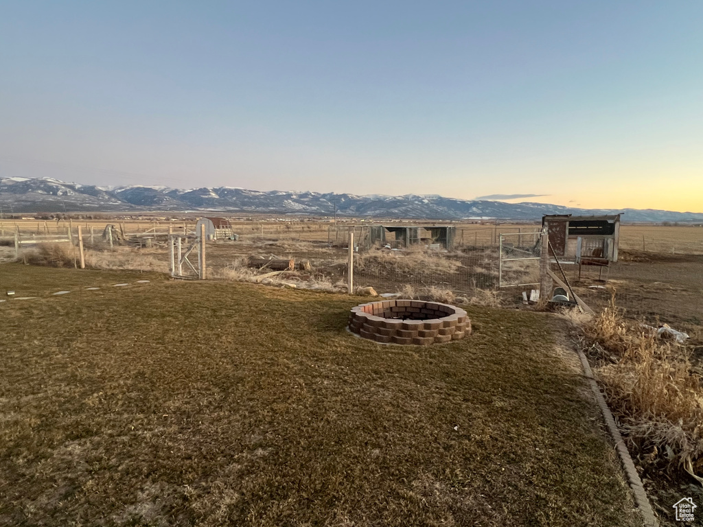 View of yard featuring an outdoor fire pit, a rural view, and a mountain view