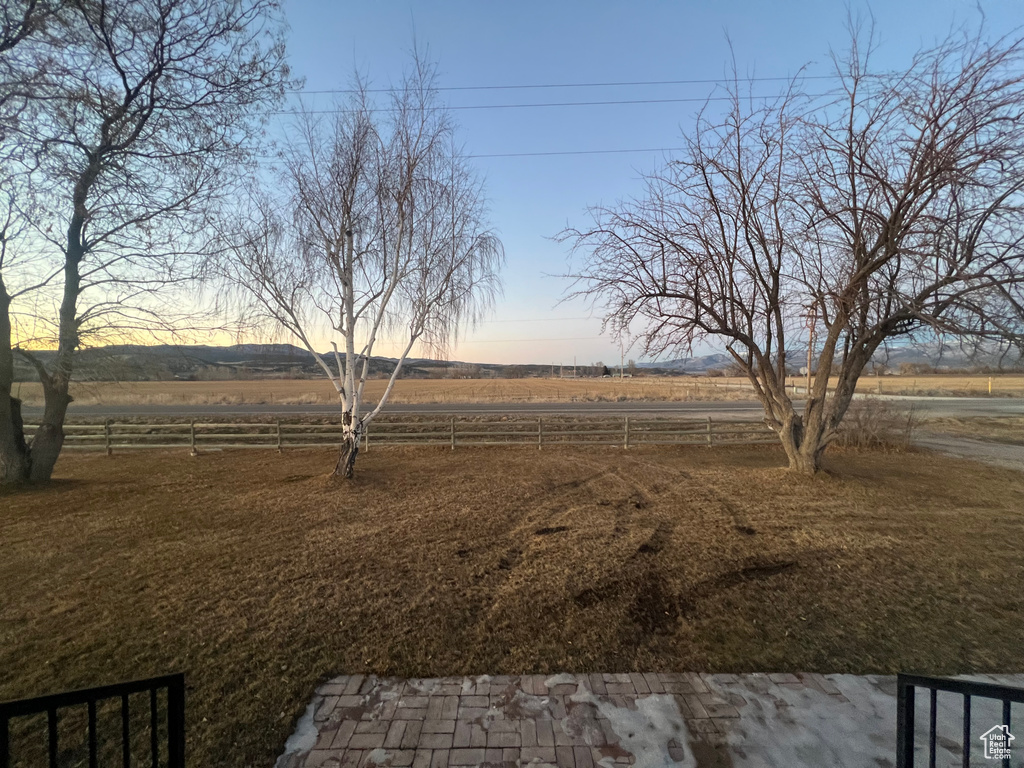 View of yard featuring a rural view and fence