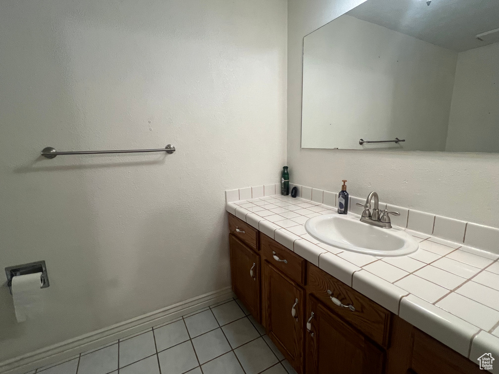 Bathroom featuring tile patterned flooring, vanity, and baseboards