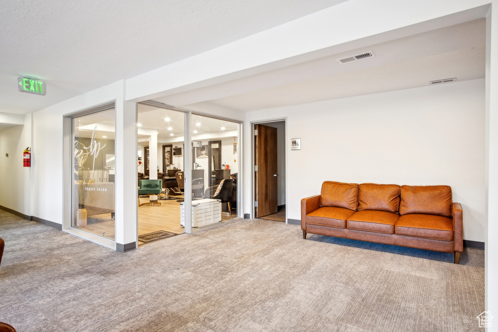Carpeted living room featuring visible vents and baseboards