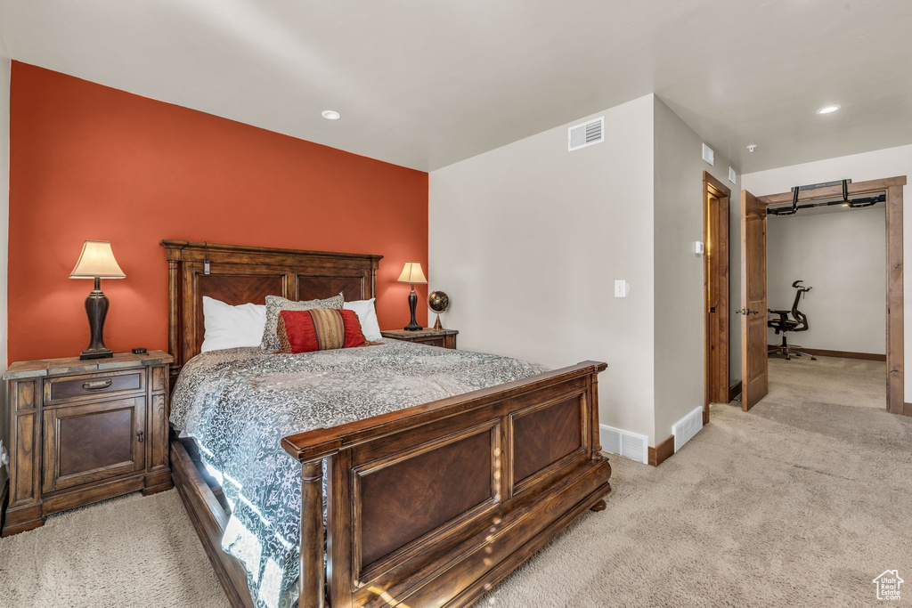 Bedroom with light colored carpet and recessed lighting