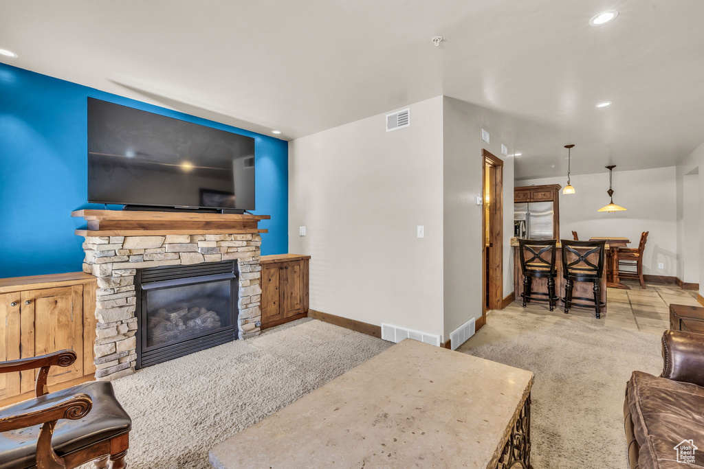 Living room featuring carpet flooring, a fireplace, and recessed lighting