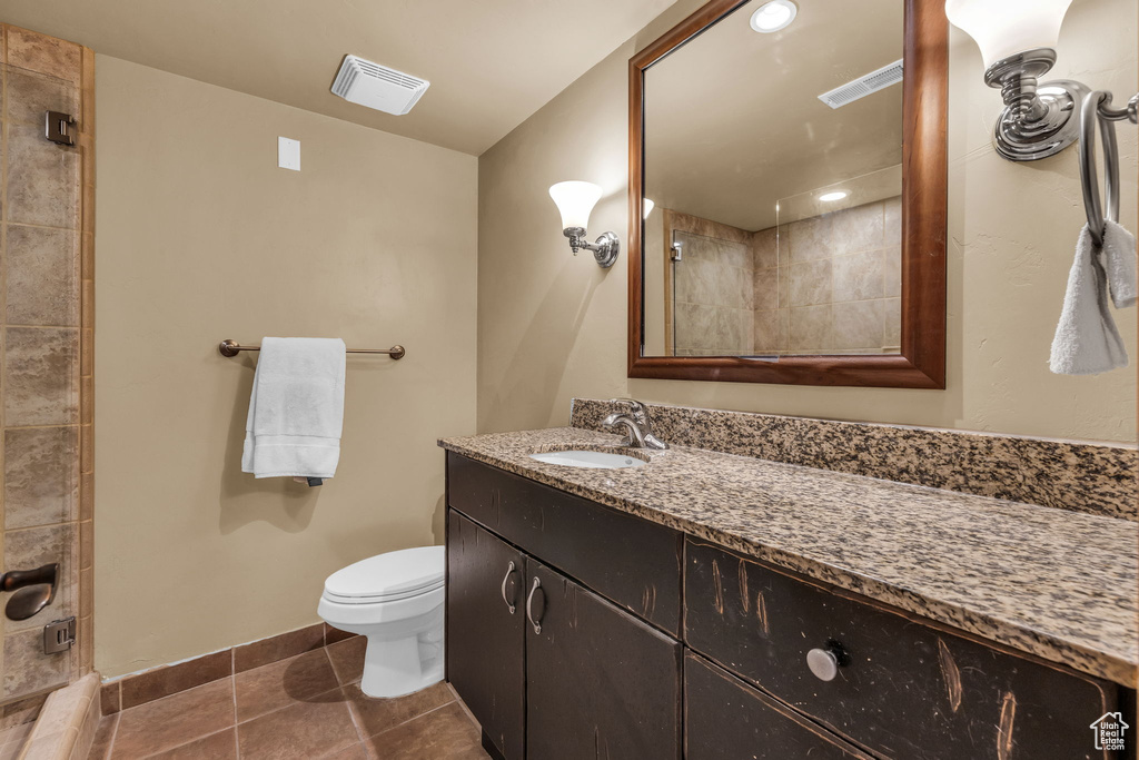 Full bath with vanity, tile patterned floors, and a tile shower