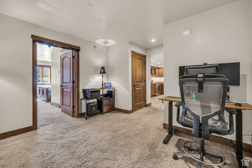 Office area with light colored carpet and recessed lighting