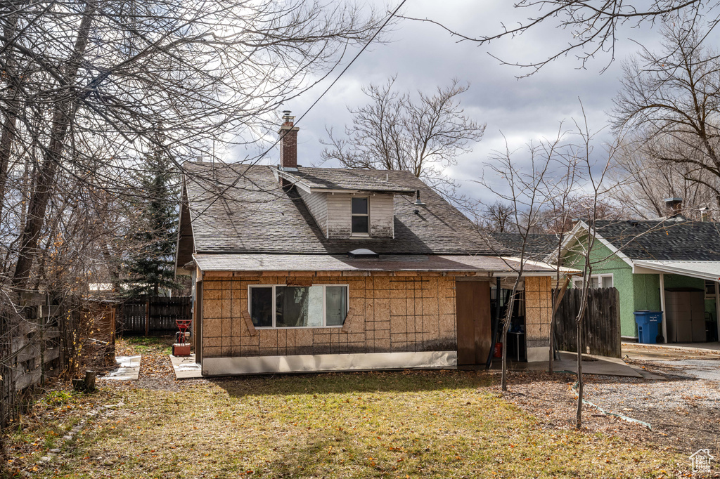 Rear view of property with a yard
