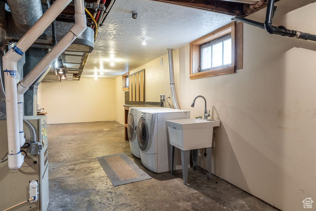 Laundry area featuring washing machine and clothes dryer and a textured ceiling
