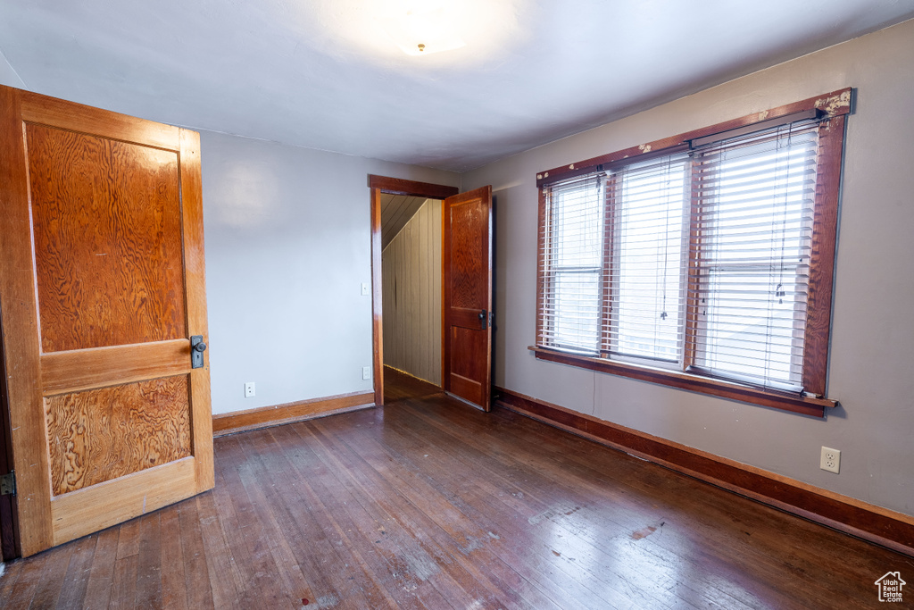 Unfurnished bedroom with dark wood-type flooring