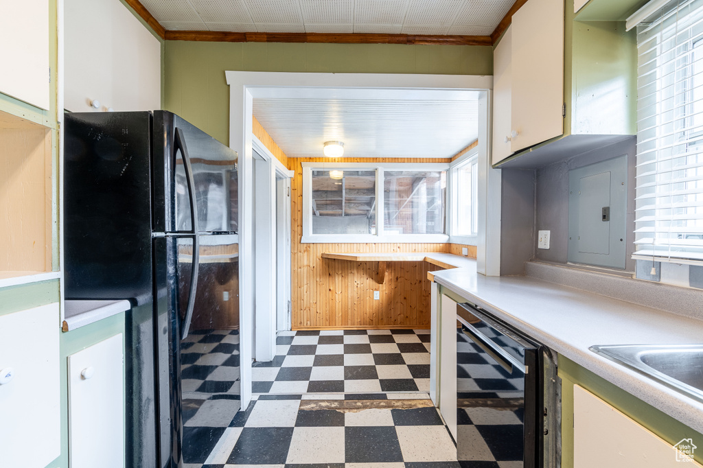 Kitchen with a healthy amount of sunlight, beverage cooler, wooden walls, and electric panel
