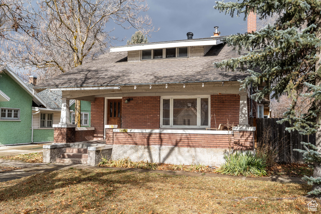 View of front facade with a front lawn and a porch