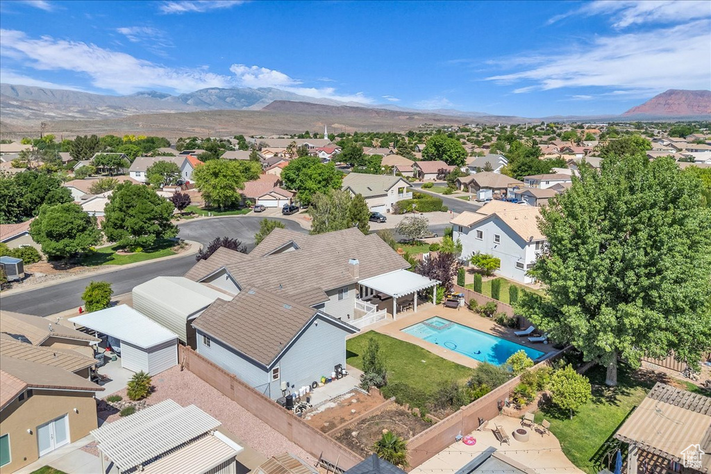 Aerial perspective of suburban area featuring a pool and a mountain backdrop