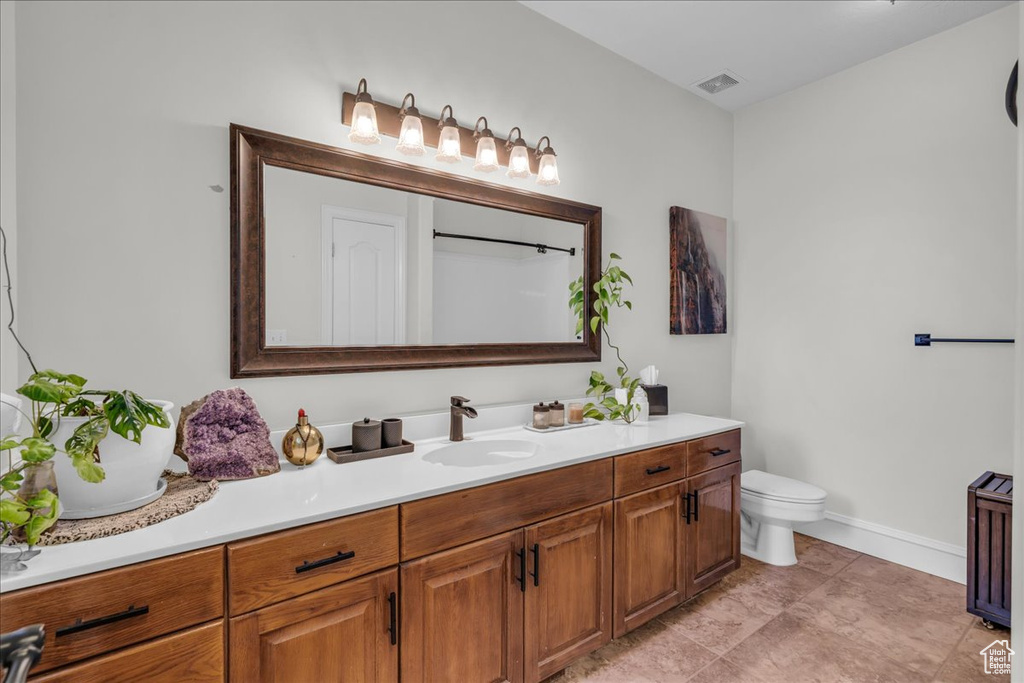 Bathroom featuring vanity, toilet, baseboards, and a shower
