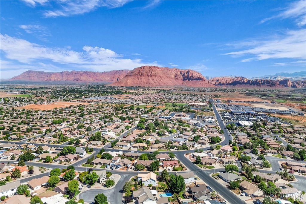 Aerial view of property and surrounding area featuring a mountain backdrop