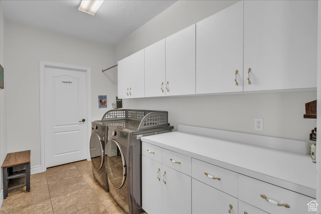 Washroom featuring cabinet space and washing machine and clothes dryer