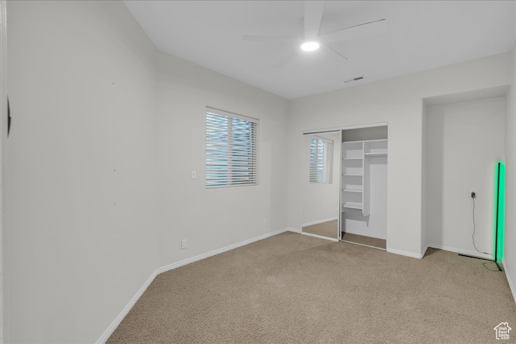 Unfurnished bedroom featuring carpet floors, baseboards, a closet, and ceiling fan