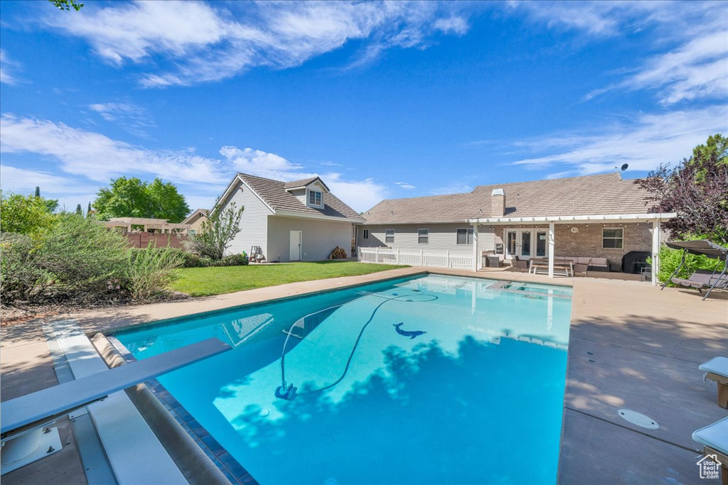 Outdoor pool with an outdoor hangout area, a patio, french doors, and a diving board