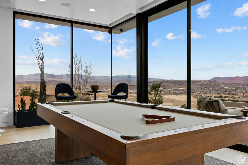 Game room with pool table, a wall of windows, wood finished floors, and a mountain view