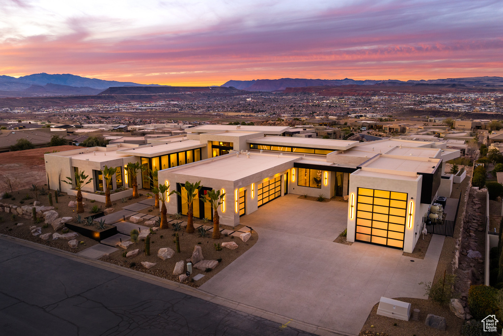 View of front of home with a garage, concrete driveway, a mountain view, and stucco siding