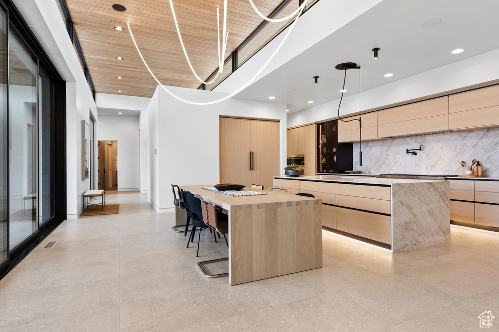 Kitchen featuring light brown cabinetry, a large island, and modern cabinets