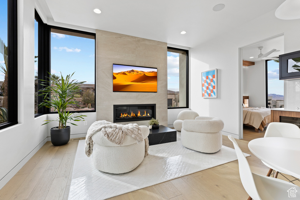 Living room featuring light wood-style floors, recessed lighting, a healthy amount of sunlight, and a tiled fireplace