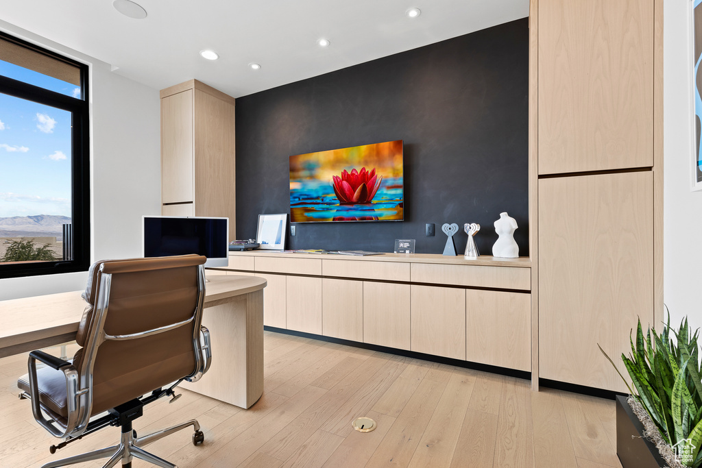 Office space featuring light wood finished floors, an accent wall, and recessed lighting