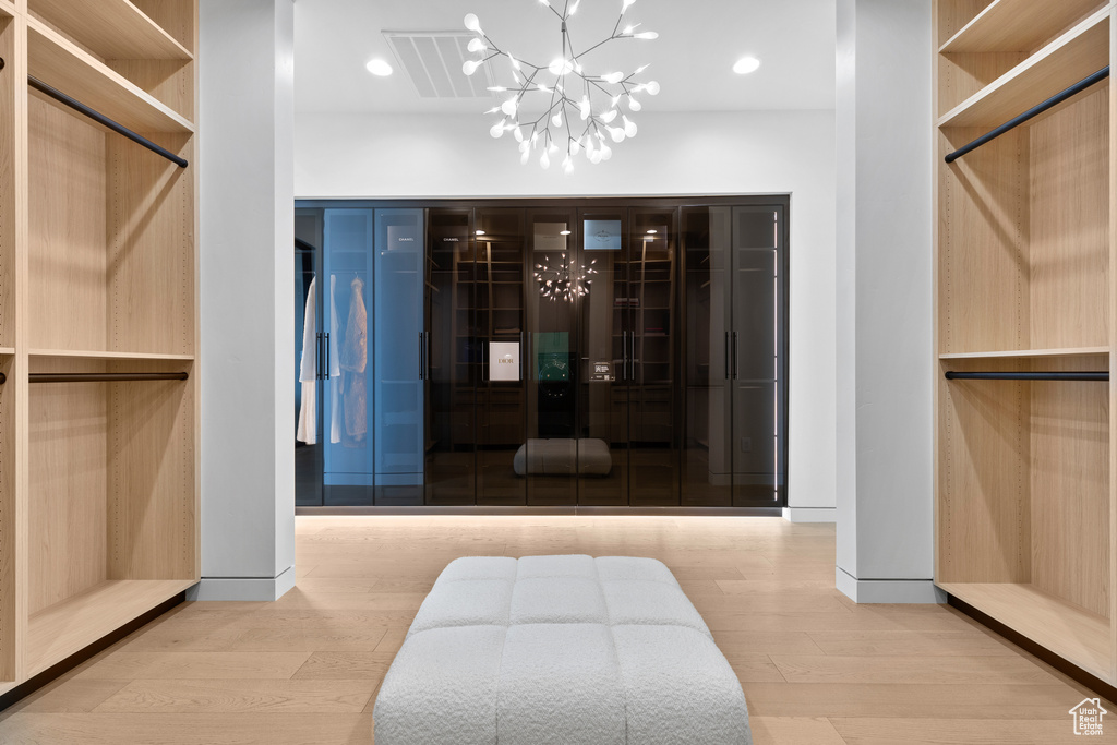 Spacious closet featuring a notable chandelier, visible vents, and light wood-style floors