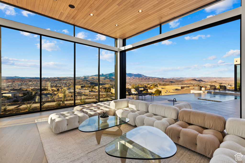 Sunroom featuring wooden ceiling and a mountain view