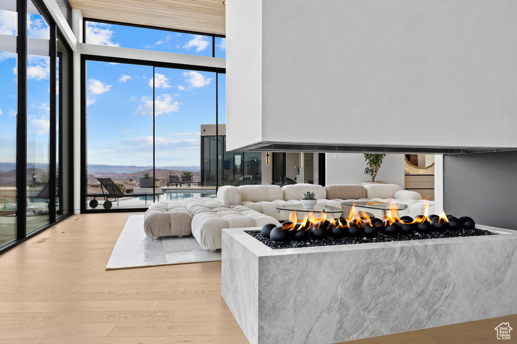 Living area with expansive windows, light wood finished floors, and a mountain view