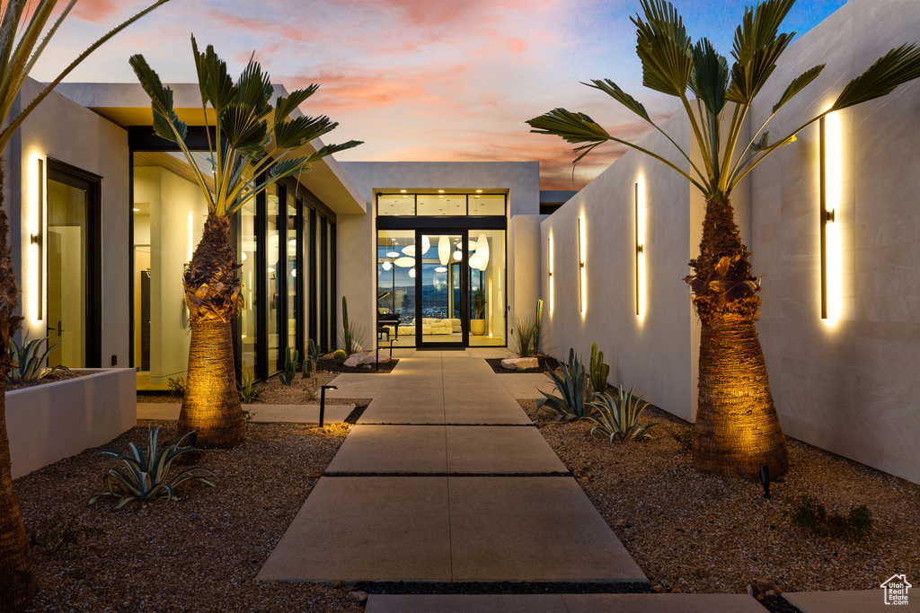 Exterior entry at dusk featuring stucco siding