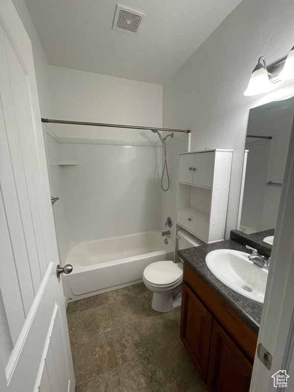 Bathroom with bathtub / shower combination, visible vents, vanity, and toilet