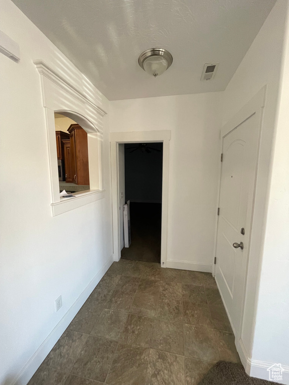 Hallway featuring radiator heating unit, visible vents, and baseboards