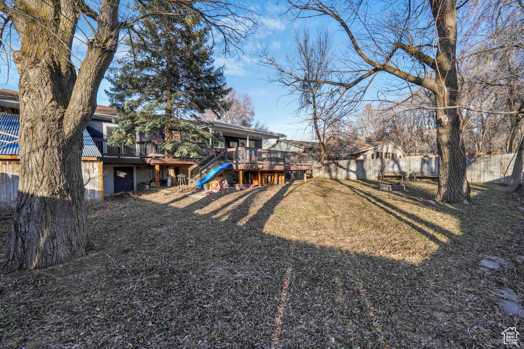 View of yard with fence private yard, a deck, and stairs
