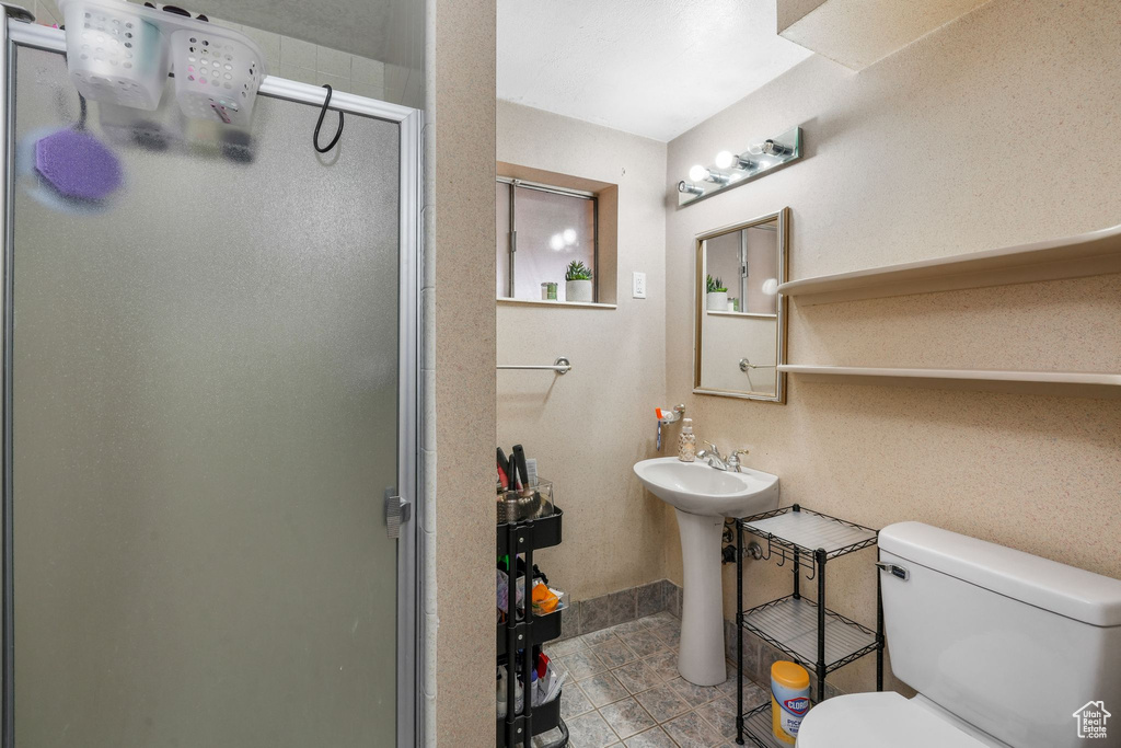 Full bath with a shower stall, toilet, and tile patterned floors