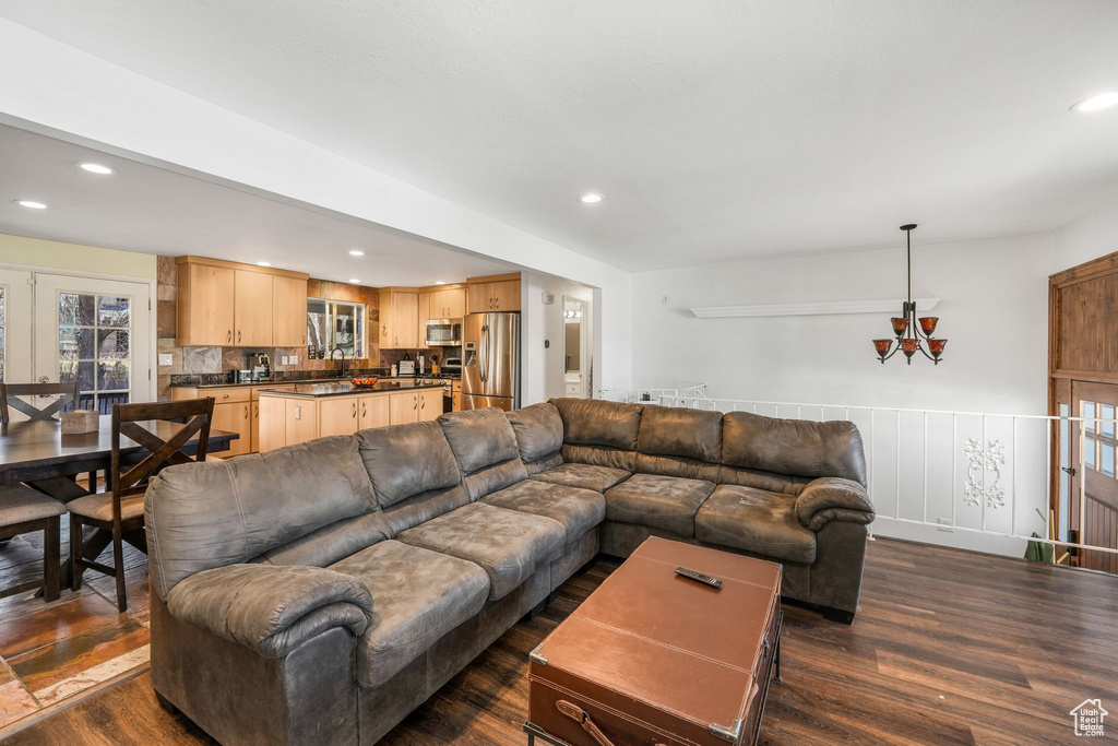Living room with dark wood-style floors, a chandelier, and recessed lighting