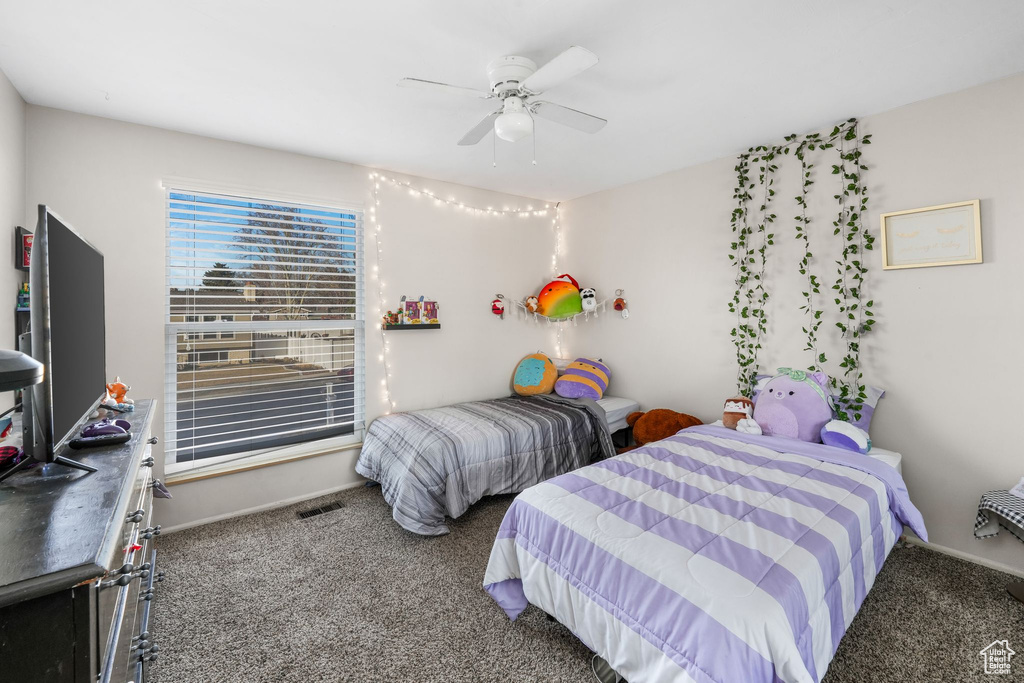 Bedroom featuring carpet flooring, ceiling fan, visible vents, and baseboards