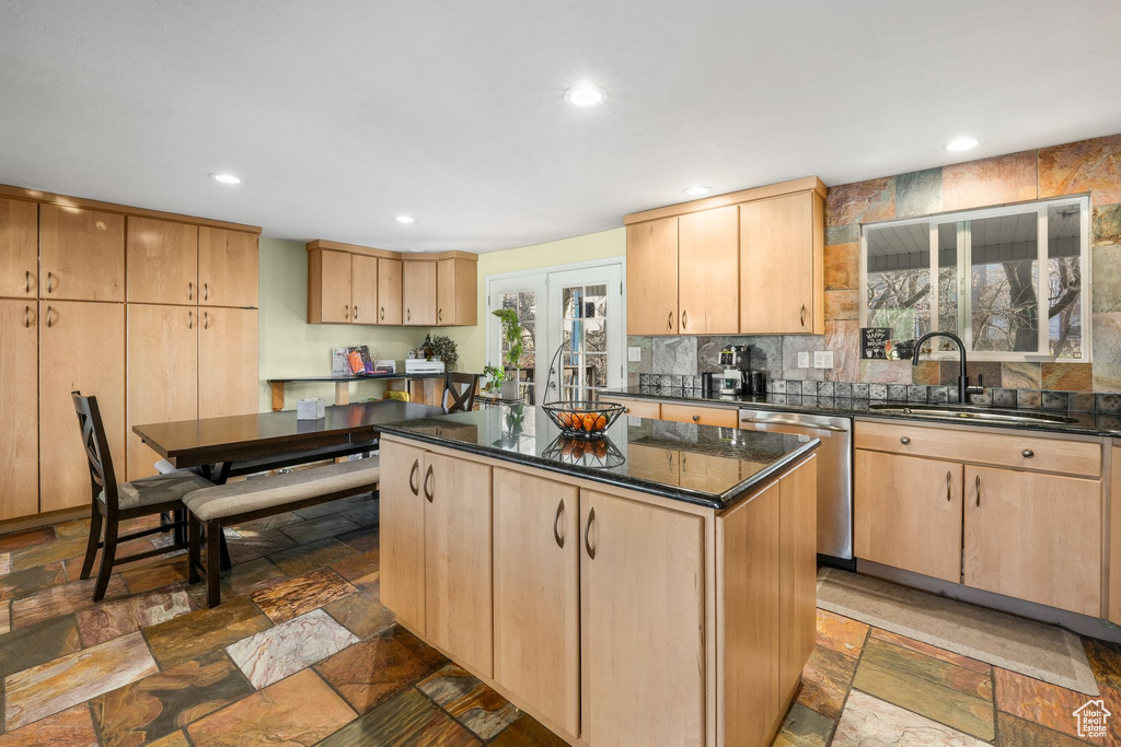 Kitchen featuring light brown cabinets, stainless steel dishwasher, and a sink