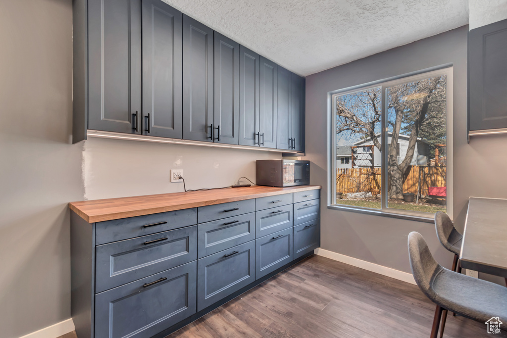 Interior space with dark wood-style floors, a textured ceiling, and baseboards