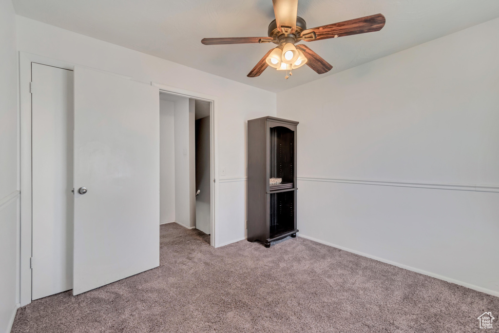 Unfurnished bedroom featuring light carpet and ceiling fan