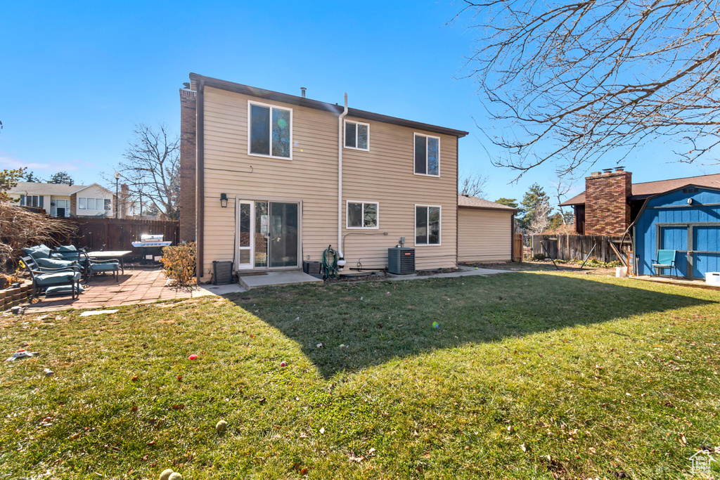 Back of property featuring an outbuilding, a yard, central air condition unit, a patio area, and a shed